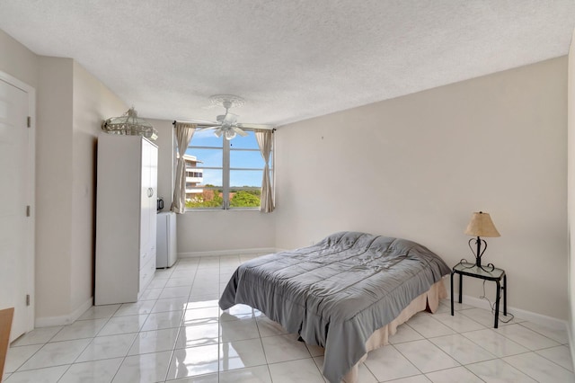 tiled bedroom with ceiling fan and a textured ceiling