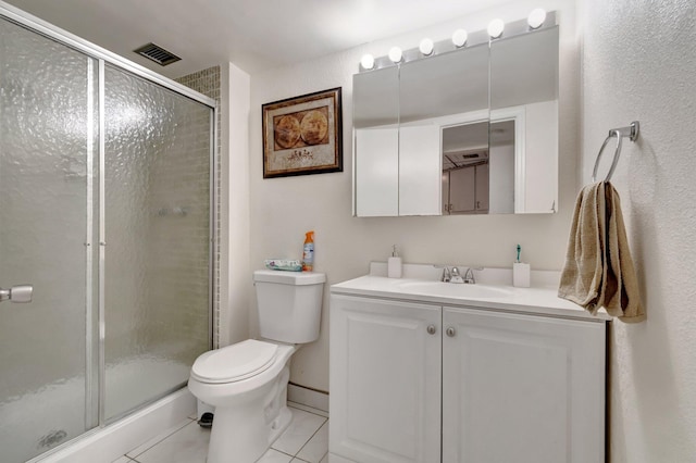 bathroom featuring tile patterned flooring, vanity, a shower with shower door, and toilet