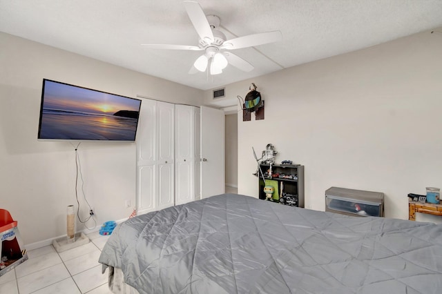 tiled bedroom featuring ceiling fan and a closet