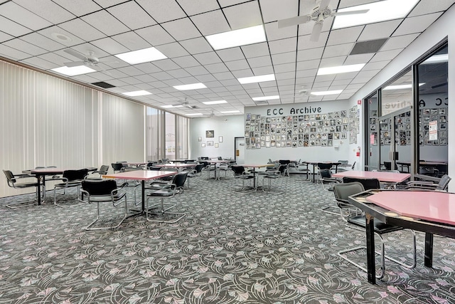 interior space featuring carpet flooring and a drop ceiling