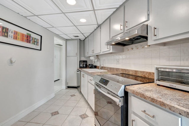 kitchen with backsplash, sink, light tile patterned floors, and stainless steel appliances