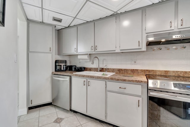 kitchen with backsplash, sink, light tile patterned floors, and appliances with stainless steel finishes