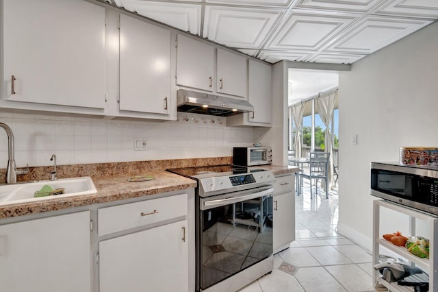 kitchen with tasteful backsplash, sink, light tile patterned flooring, and stainless steel appliances