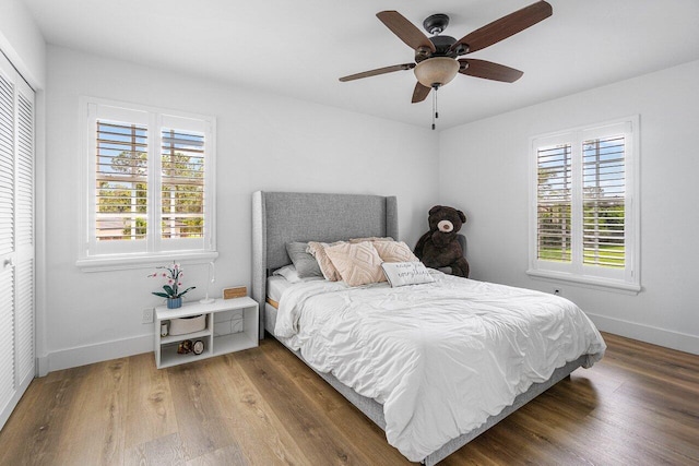 bedroom featuring dark wood-type flooring, ceiling fan, and a closet