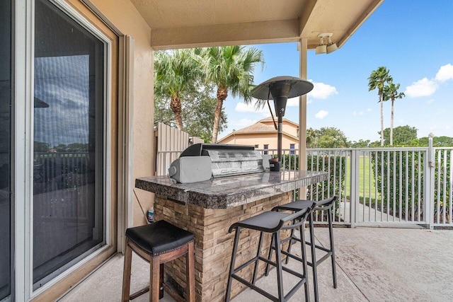 view of patio / terrace featuring exterior bar and an outdoor kitchen