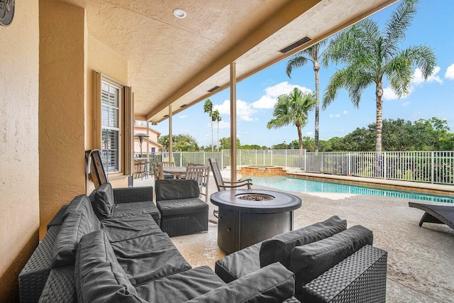 view of patio / terrace featuring a fenced in pool and an outdoor living space with a fire pit