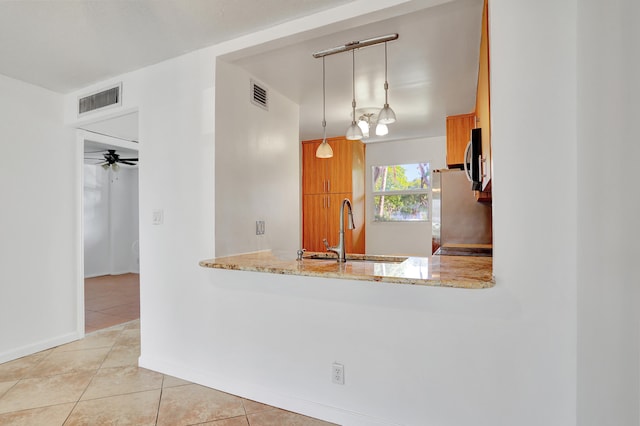 kitchen with sink, hanging light fixtures, ceiling fan, light tile patterned floors, and appliances with stainless steel finishes