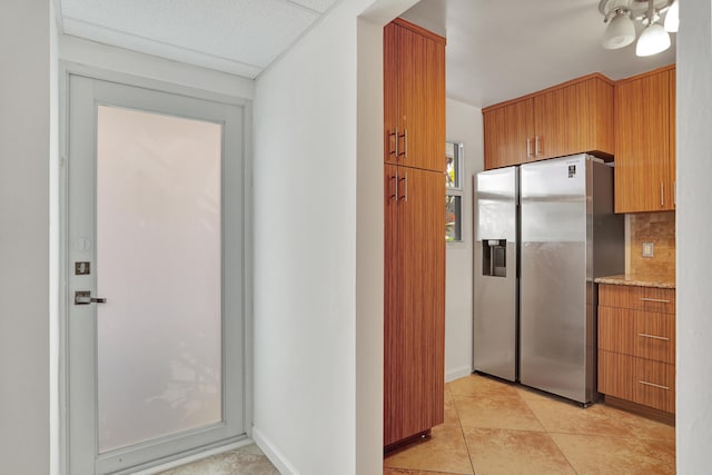 kitchen with decorative backsplash, stainless steel fridge with ice dispenser, and light tile patterned floors