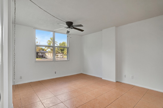 empty room featuring ceiling fan and light tile patterned flooring