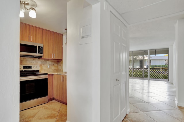 kitchen featuring decorative backsplash, light tile patterned flooring, and stainless steel appliances