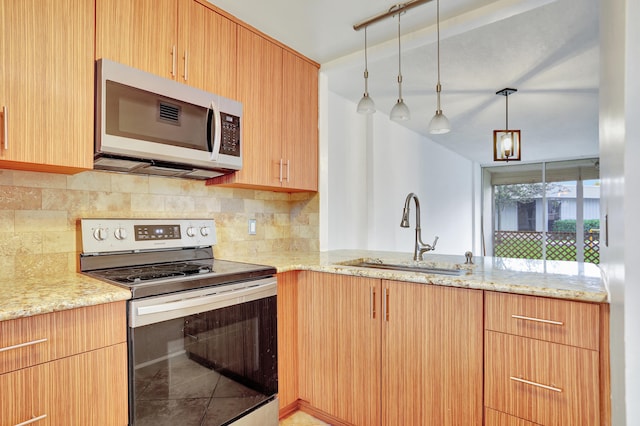 kitchen with light stone countertops, decorative backsplash, stainless steel appliances, sink, and pendant lighting