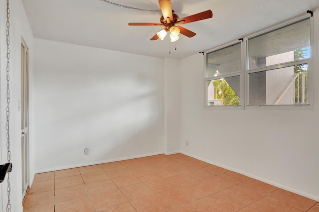 tiled empty room featuring ceiling fan