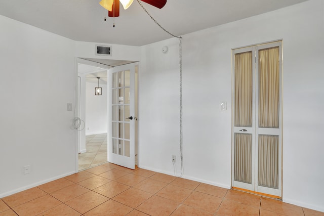 empty room with light tile patterned floors and ceiling fan