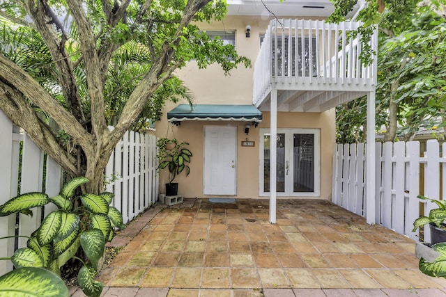 1912 NE 6th St, Deerfield Beach, FL 33441 - view of exterior entry with french doors, stucco siding, fence, and a patio area