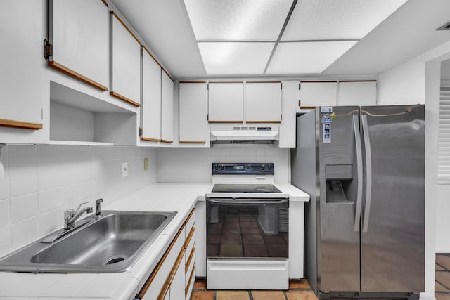 1912 NE 6th St, Deerfield Beach, FL 33441 - kitchen featuring stainless steel fridge, white range with electric stovetop, under cabinet range hood, a sink, and backsplash