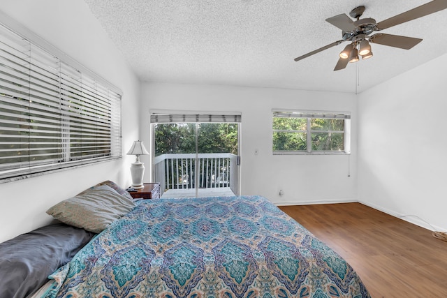 bedroom featuring hardwood / wood-style flooring, ceiling fan, a textured ceiling, and access to outside