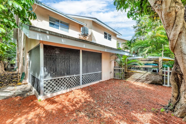 back of house featuring a sunroom and central AC unit