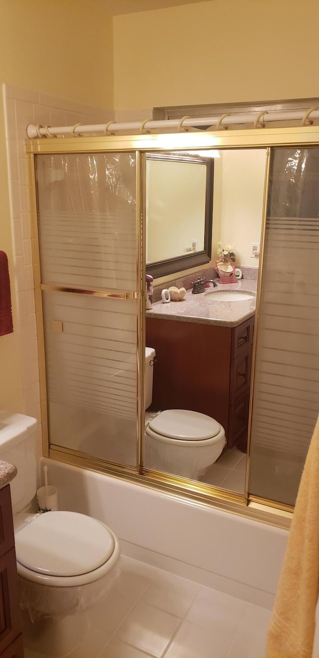 full bathroom with toilet, bath / shower combo with glass door, vanity, and tile patterned floors