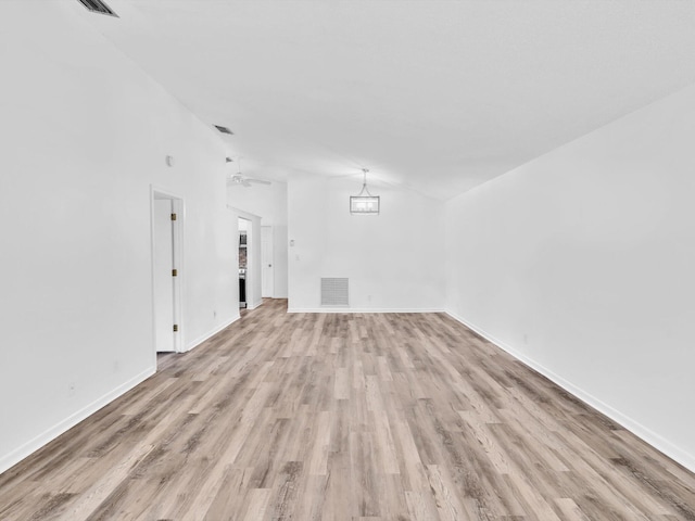 spare room featuring light wood-type flooring, lofted ceiling, and ceiling fan