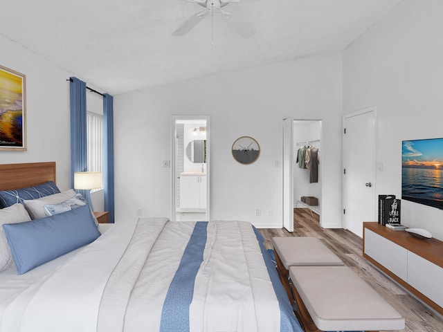 bedroom featuring connected bathroom, lofted ceiling, ceiling fan, and light hardwood / wood-style flooring