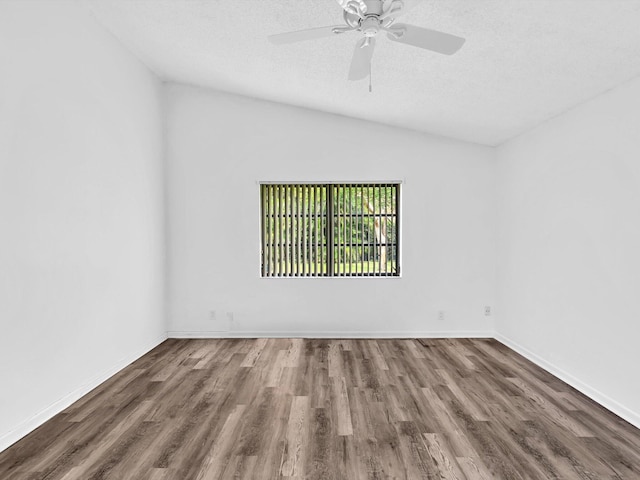 empty room with hardwood / wood-style floors, vaulted ceiling, ceiling fan, and a textured ceiling