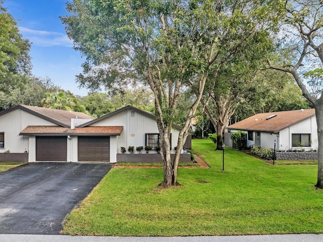 ranch-style home featuring a front lawn and a garage