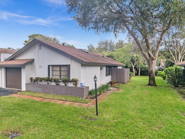 view of home's exterior with a garage and a lawn