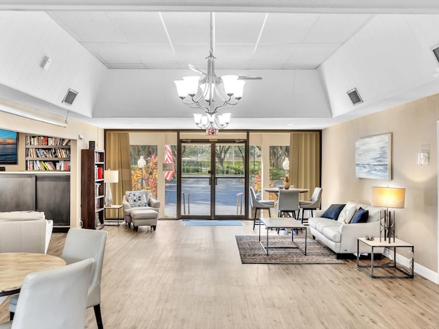 living room with hardwood / wood-style floors, a chandelier, and built in shelves