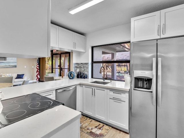 kitchen featuring white cabinetry, appliances with stainless steel finishes, sink, and light hardwood / wood-style floors