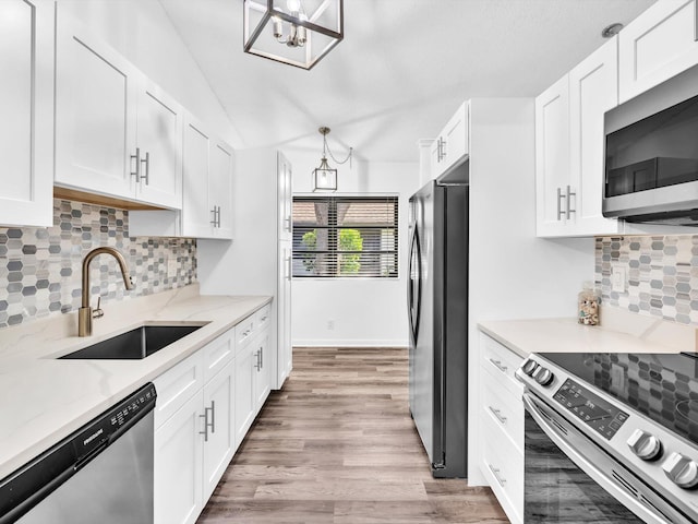 kitchen with light wood-type flooring, white cabinets, sink, and stainless steel appliances