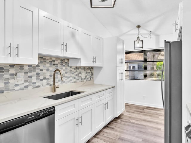 kitchen featuring white cabinetry, appliances with stainless steel finishes, light wood-type flooring, light stone countertops, and sink