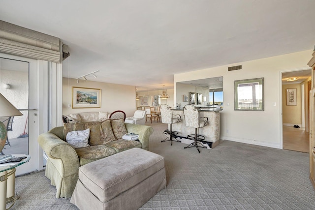 carpeted living room featuring track lighting