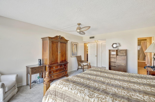 carpeted bedroom featuring ceiling fan and a textured ceiling