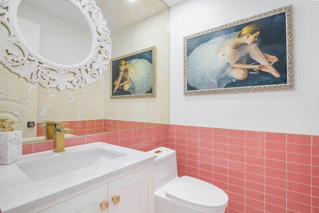 bathroom featuring vanity, toilet, and tile walls