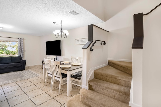 dining space with light tile patterned floors, a textured ceiling, and an inviting chandelier