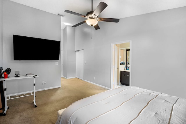 carpeted bedroom with ensuite bathroom and ceiling fan