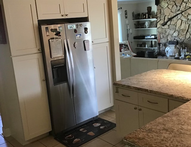 kitchen featuring white cabinets, stainless steel fridge with ice dispenser, and light tile patterned flooring