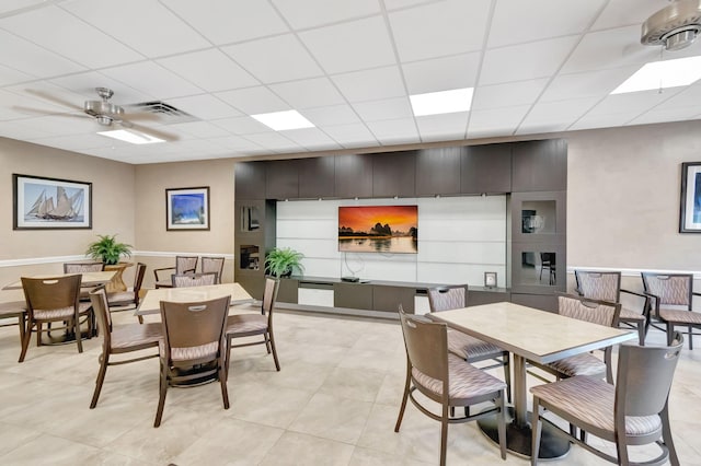 dining room featuring ceiling fan, a paneled ceiling, and light tile patterned floors