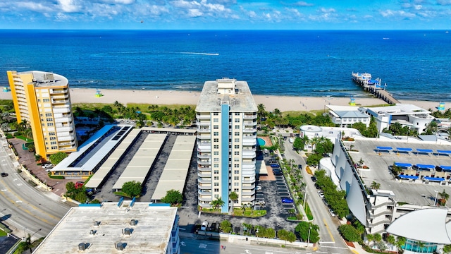 birds eye view of property featuring a water view and a beach view