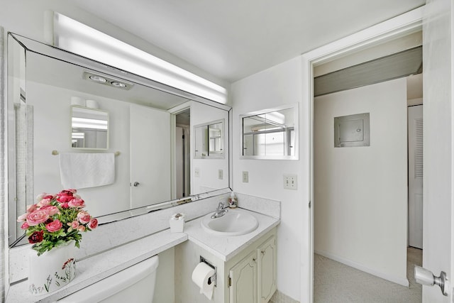 bathroom featuring vanity, electric panel, and toilet