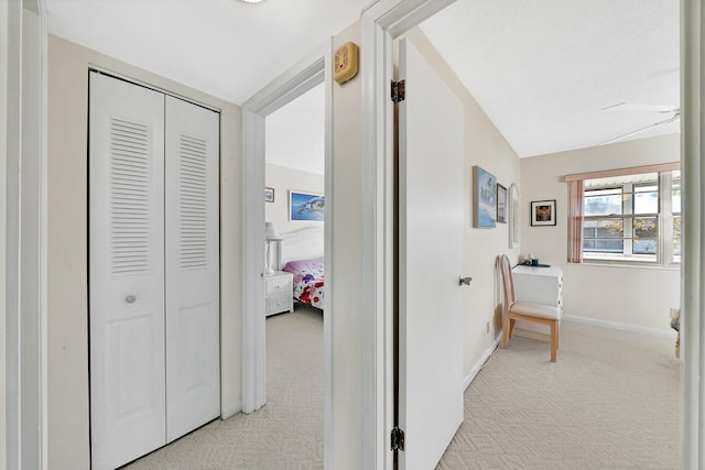 hall featuring light colored carpet and vaulted ceiling