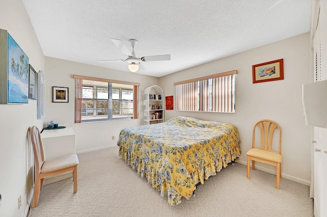 bedroom with a textured ceiling, carpet floors, and ceiling fan