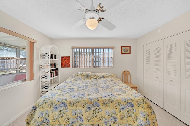 carpeted bedroom featuring ceiling fan, a textured ceiling, and a closet