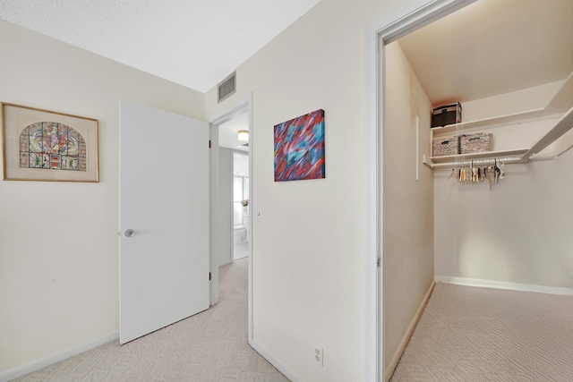 hall featuring light colored carpet