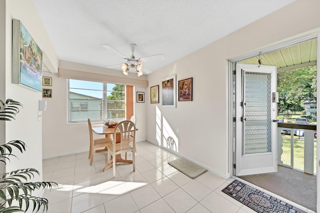 dining room featuring ceiling fan, light tile patterned floors, and a textured ceiling