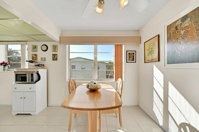 tiled dining space with a textured ceiling and a wealth of natural light