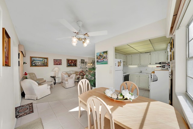 tiled dining room with ceiling fan and a drop ceiling