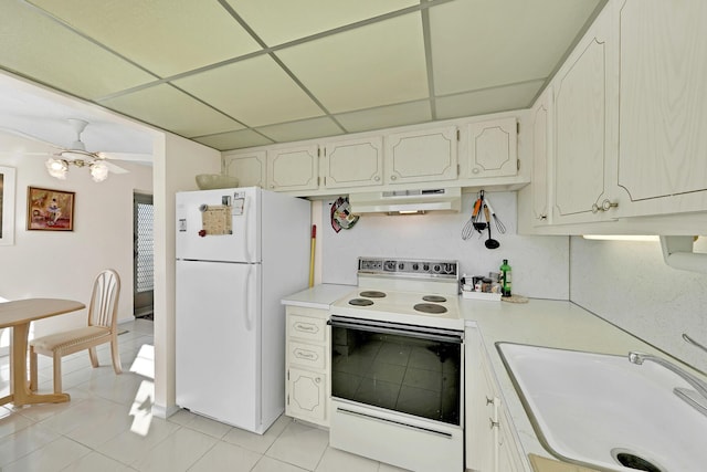 kitchen with a paneled ceiling, white appliances, ceiling fan, sink, and white cabinetry