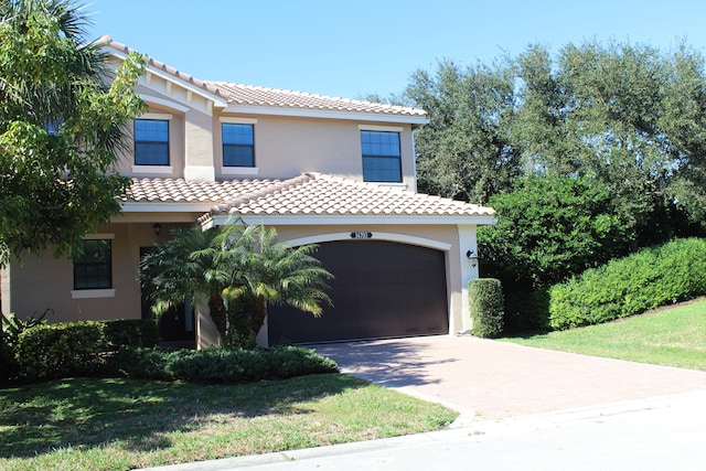 mediterranean / spanish-style house featuring a front yard and a garage