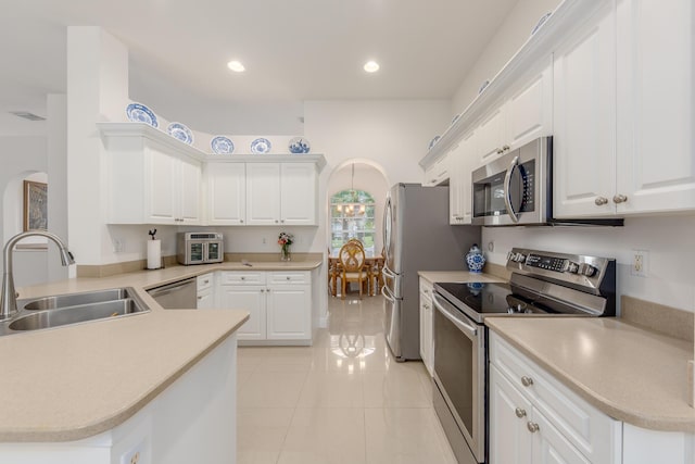 308 SW Egret Lndg, Port Saint Lucie, FL 34953 - kitchen featuring appliances with stainless steel finishes, a sink, arched walkways, light tile patterned flooring, and white cabinetry